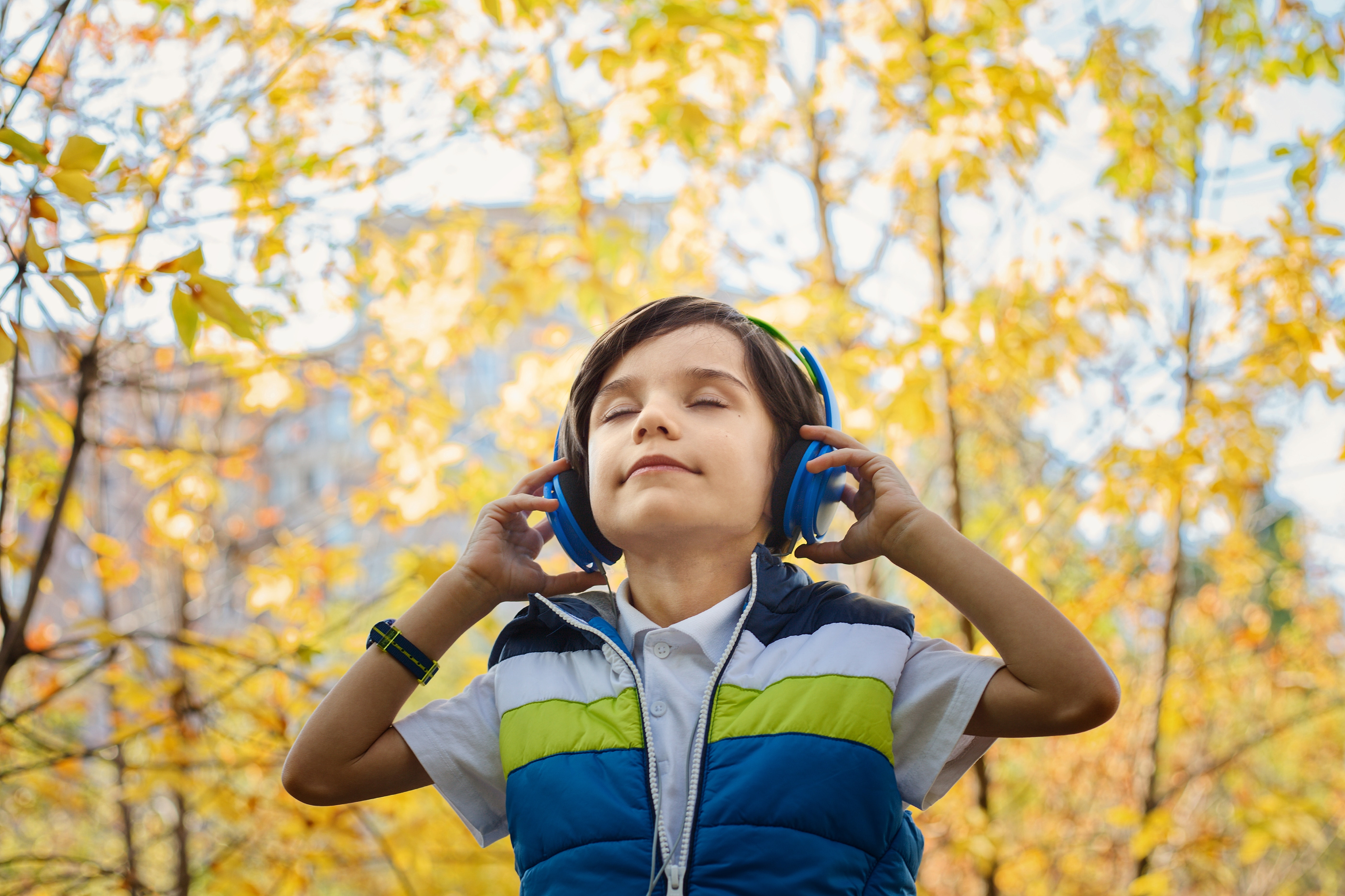 Kid in bliss Listening to music with headphones in a park