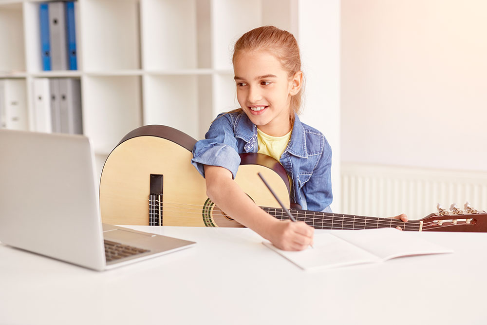 girl doing guitar homework